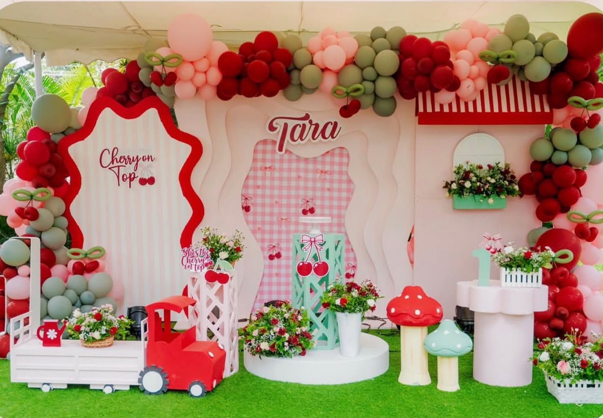 Pastel pink and mint green birthday arches with floral arrangements and dessert cart