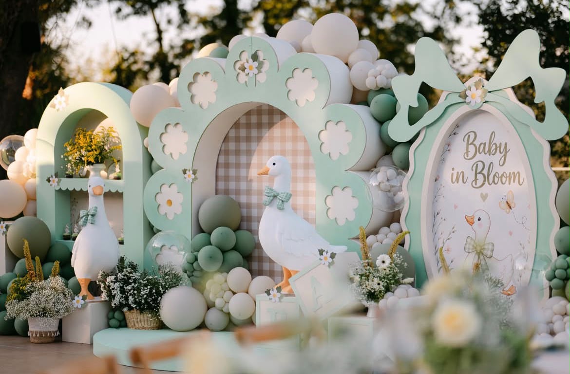 Garden party birthday celebration with picnic tables, balloons and festive bunting