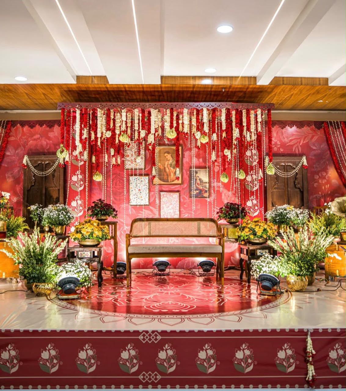 The Utsav House bespoke engagement stage backdrop with golden arches and fresh pastel florals