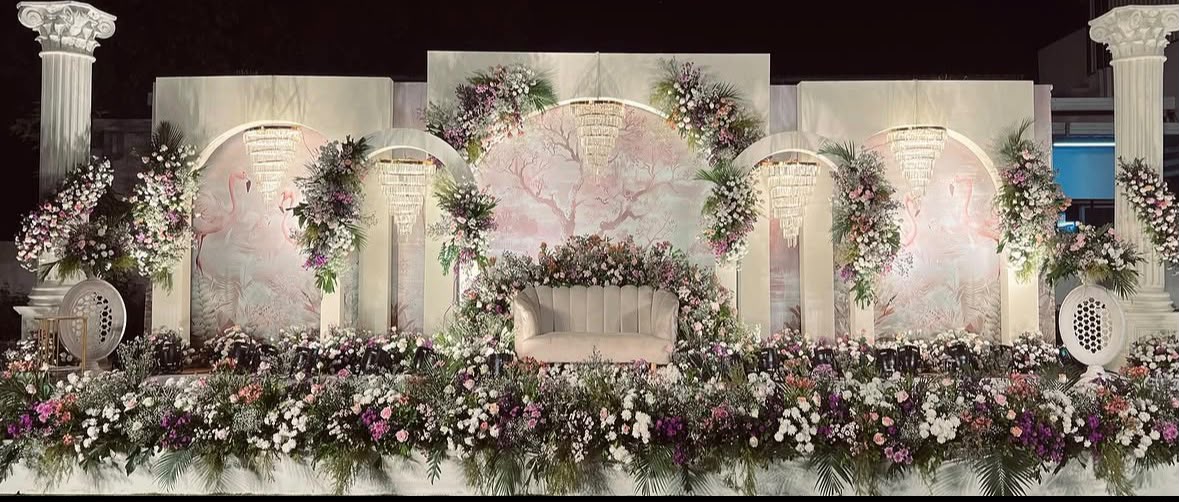 Enchanting evening engagement stage styling with fairy-light canopy and botanical installations