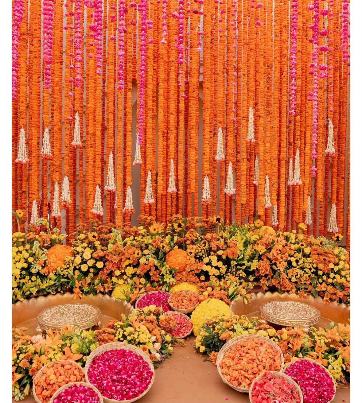 Garden haldi mandap with pastel drapery, lotus tubs, and sunflower clusters