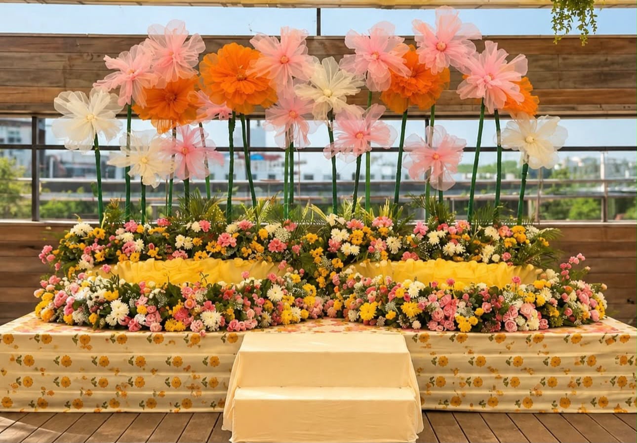 Scenic outdoor haldi seating with custom printed backdrops and yellow blooms