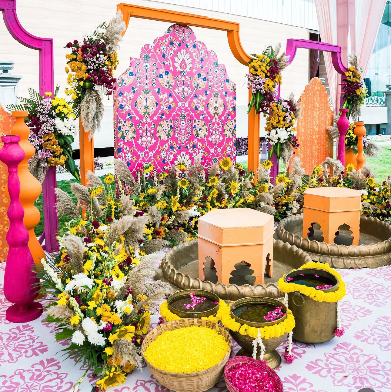 Sun-drenched haldi ceremony area with handcrafted floral swings and cushions
