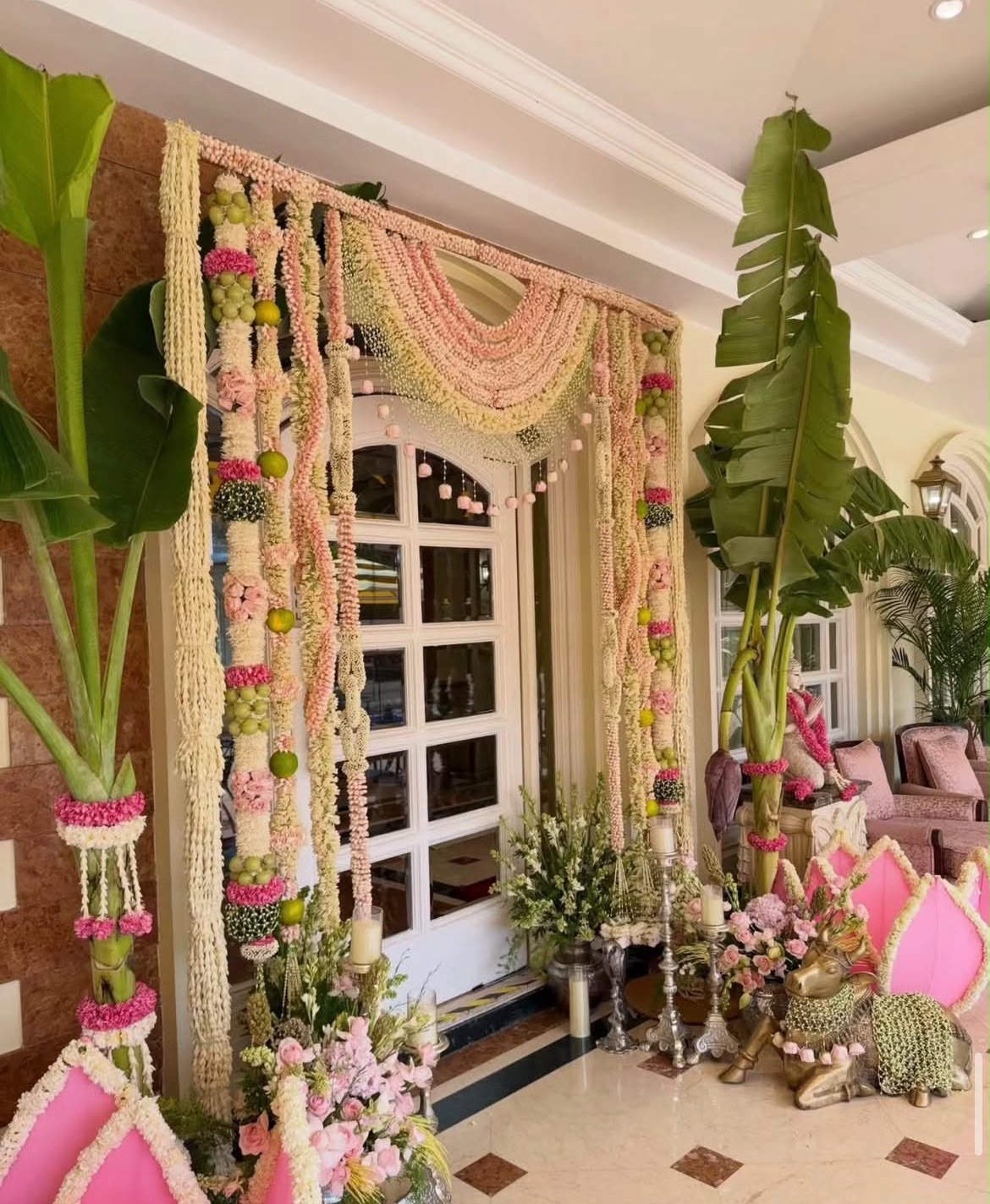 Handcrafted wooden mandir styling at home with brass samayi lamps and fresh floral garlands