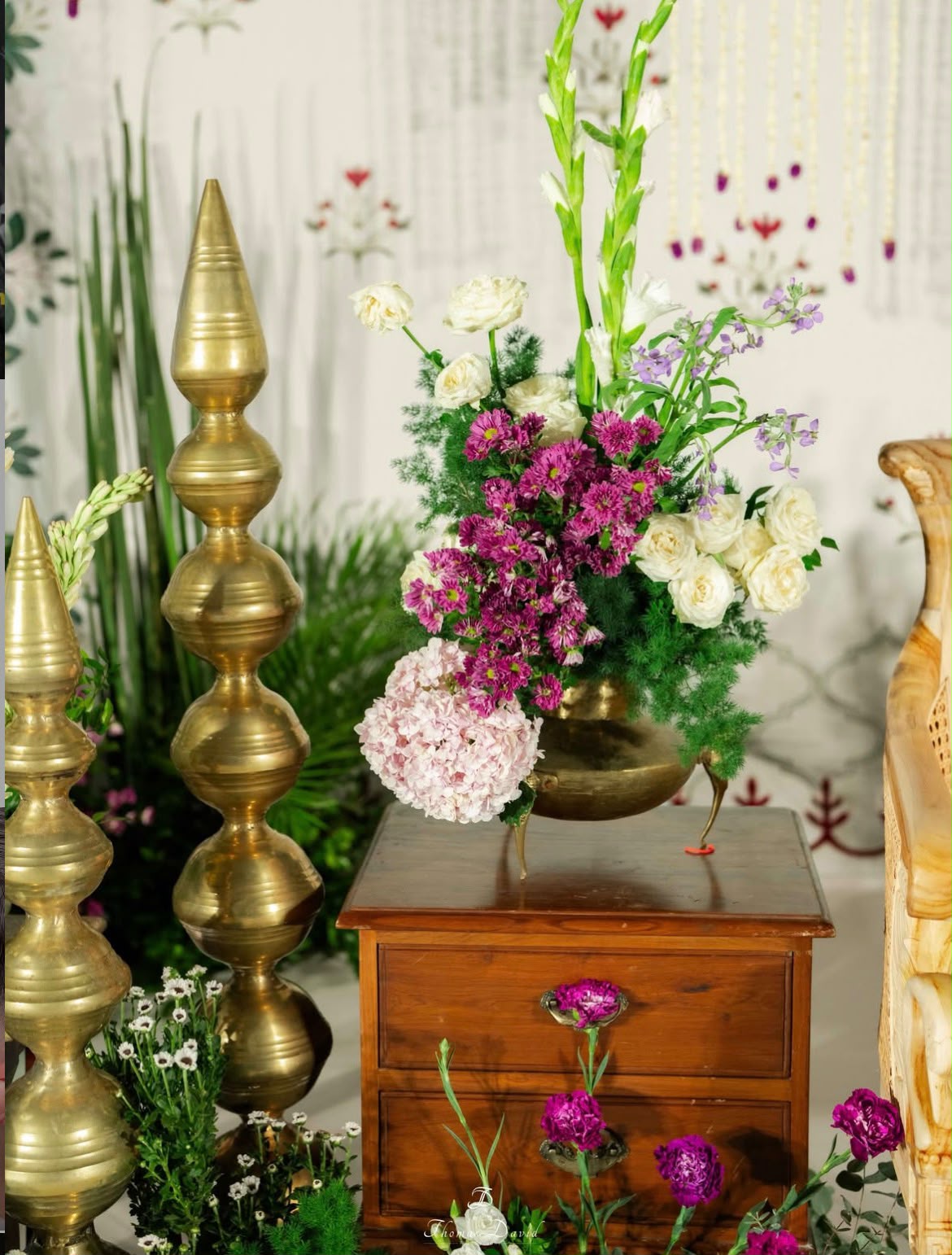 Cozy indoor celebration corner styled with traditional brass tableware and marigold strings
