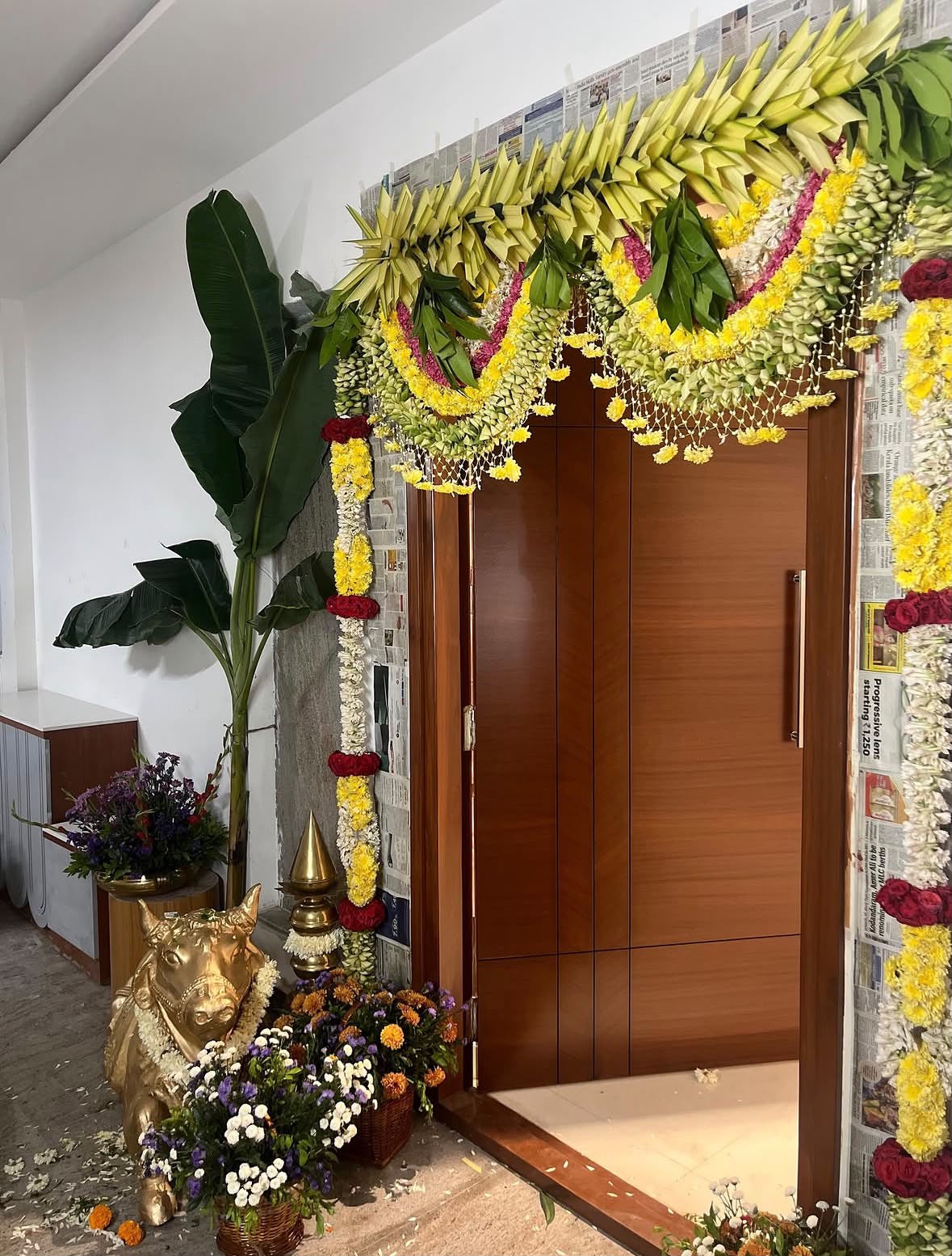 Home corridor walkway adorned with flower petals, brass lamps, and welcome floral stands