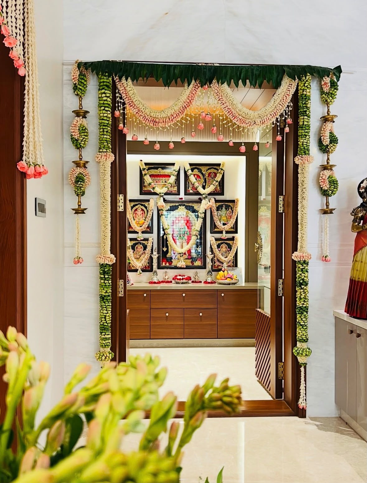 Traditional indoor family ritual setup with wooden peeta seating and silver pooja items