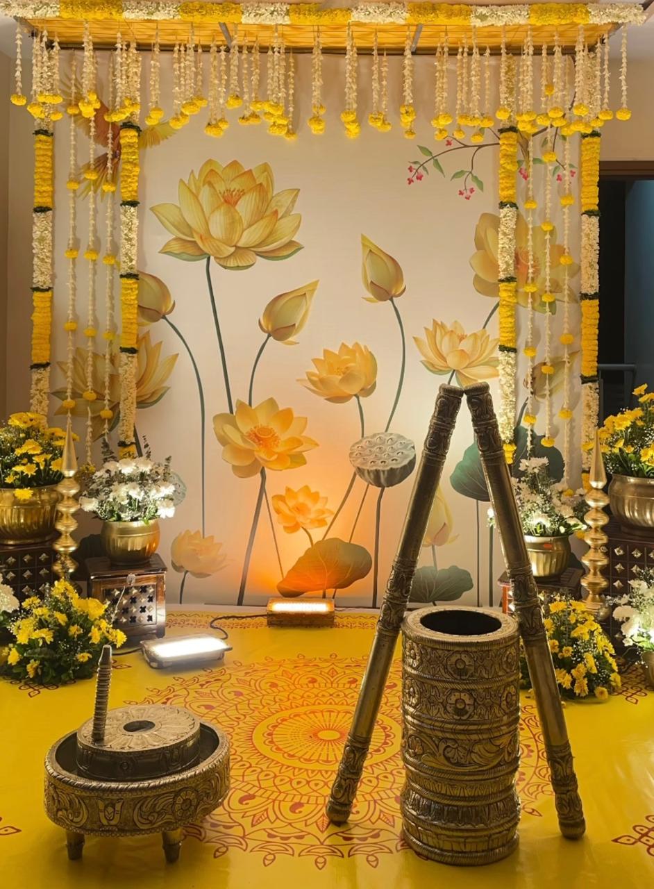Home ceremony corner with antique brass planters, marigold strings, and soft backlighting
