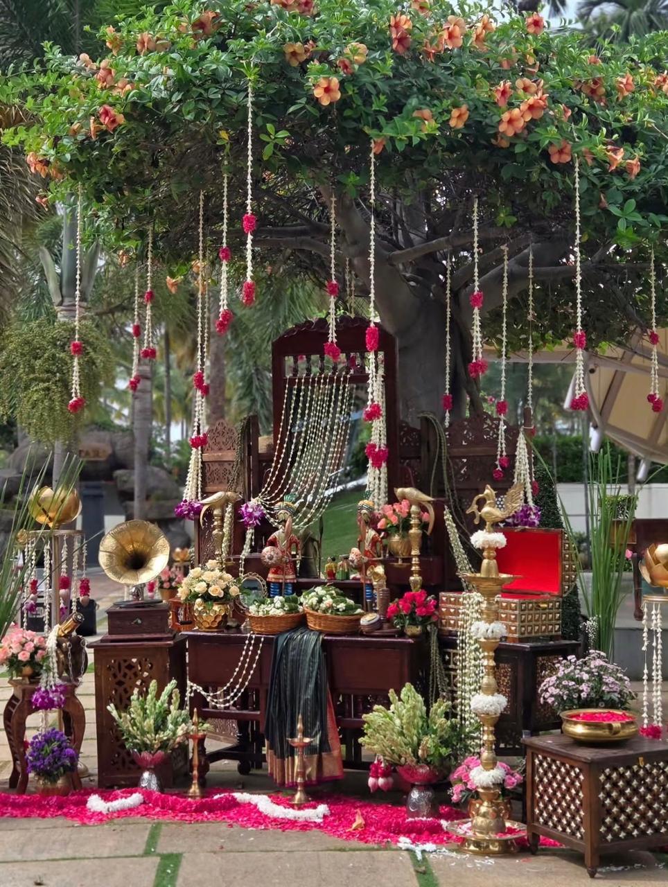 Sacred wooden carved doorway backdrop adorned with floral garlands for pellikoduku