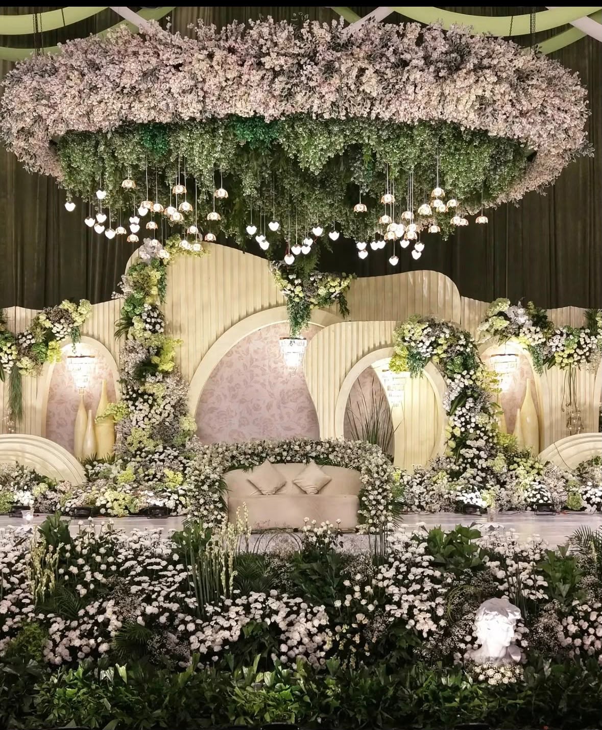Ambient reception hall illumination with warm mood lighting and suspended floral clouds