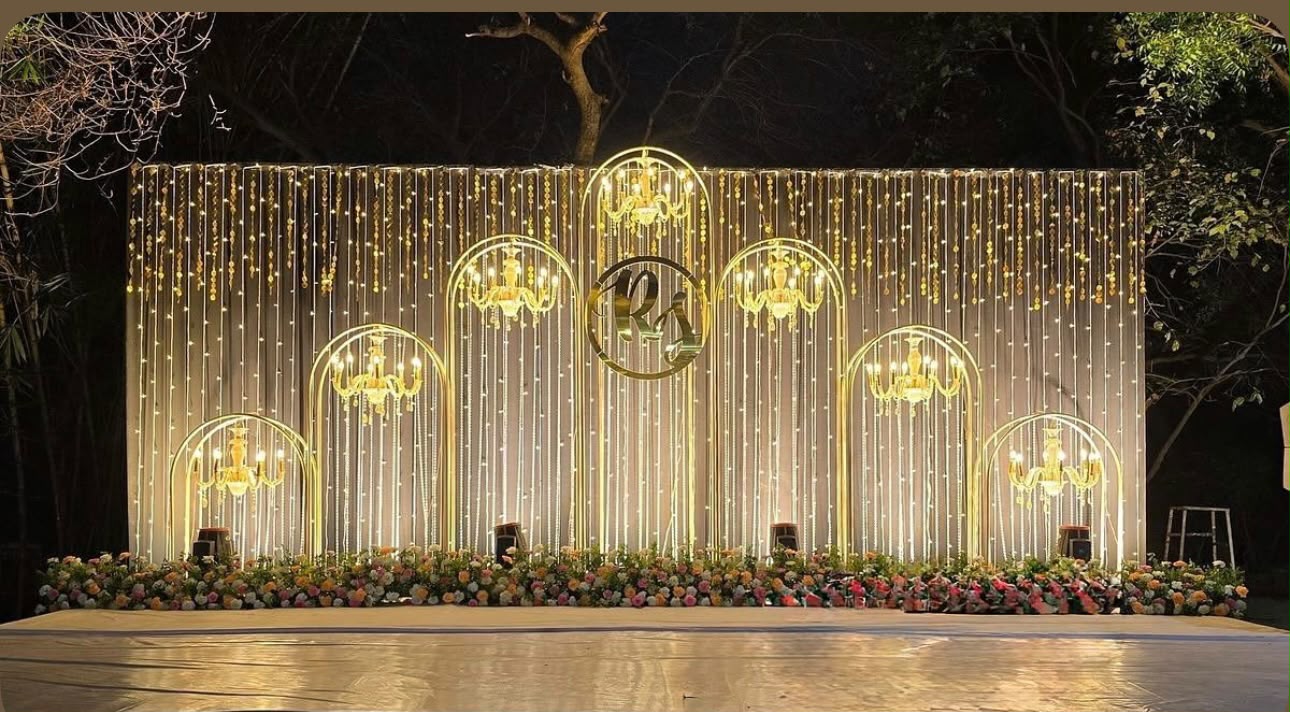 Glamorous Sangeeth stage with illuminated golden arches and crystal chandeliers