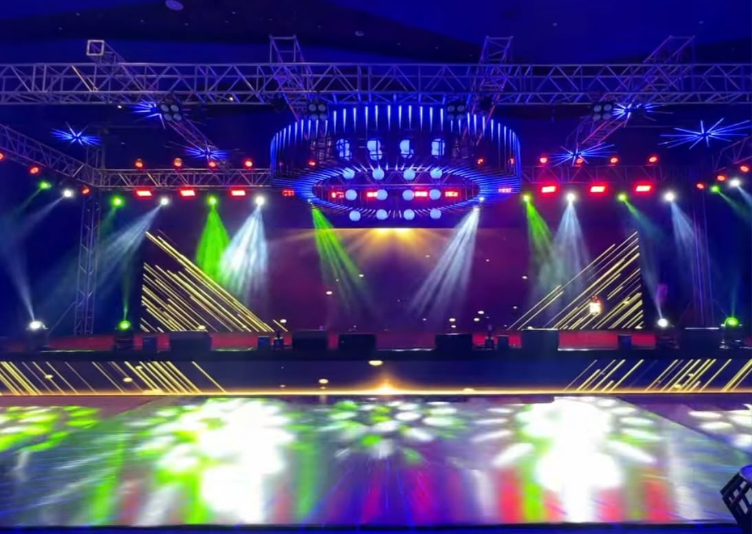 Illuminated sangeeth performance stage backdrop with personalized couple monogram