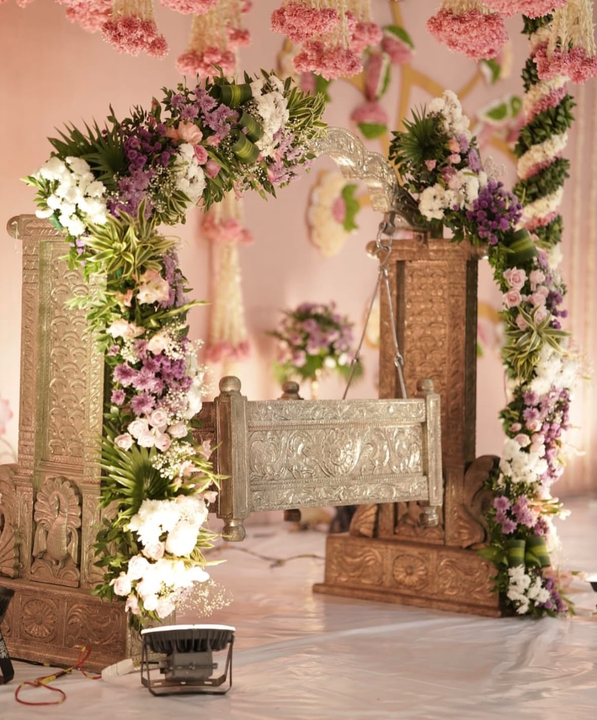Sunlit courtyard festive celebration setup with vibrant marigold torans and brass samayis
