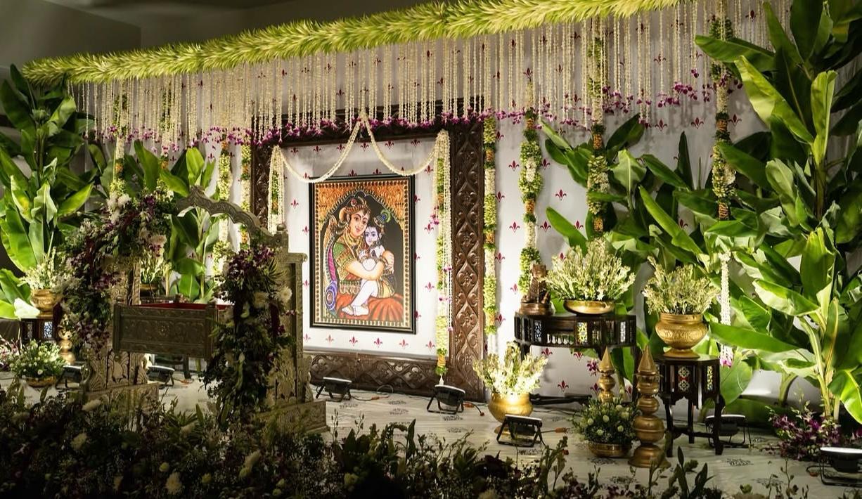 Intimate family festive pooja stage with woven palm leaves and fragrant yellow marigolds