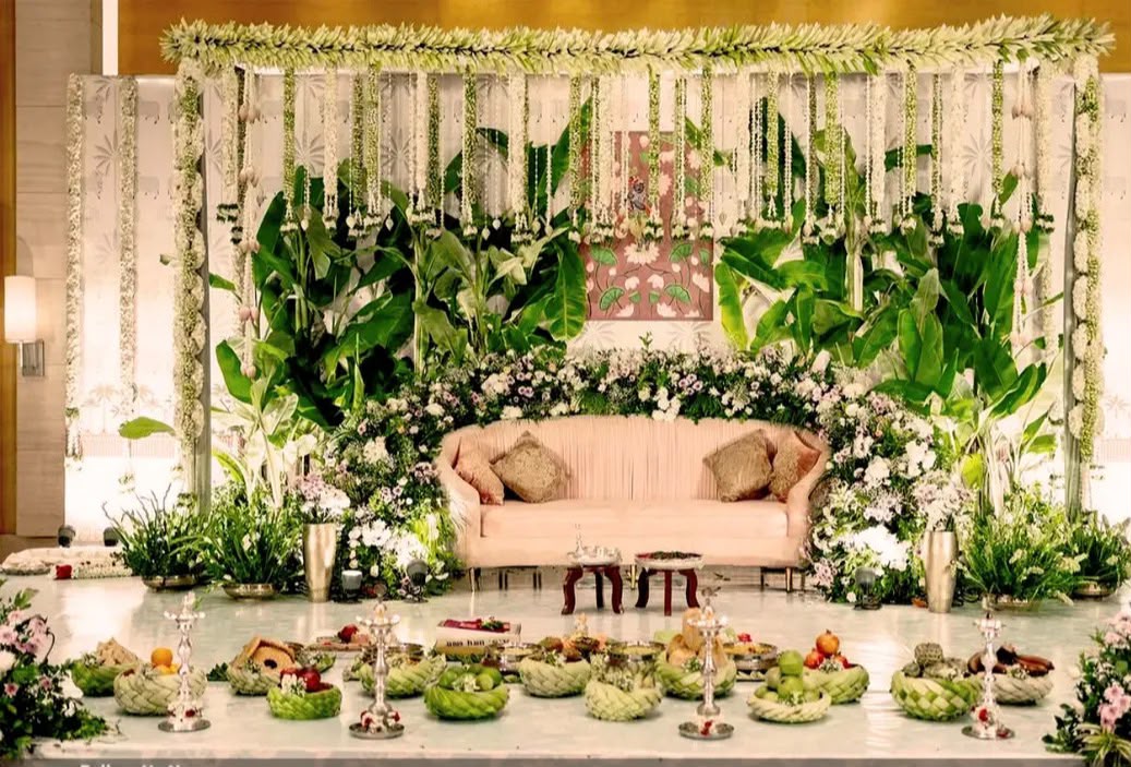 Serene pooja backdrop with lotus motifs, brass bell drapes, and hanging flower balls