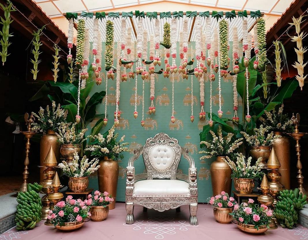 Opulent traditional celebration stage featuring gold carved jali screens and red rose garlands