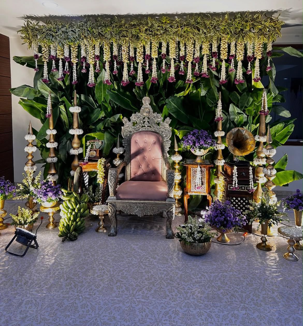Traditional cradle ceremony setup with ornate brass chains, hanging tassels, and soft cushions
