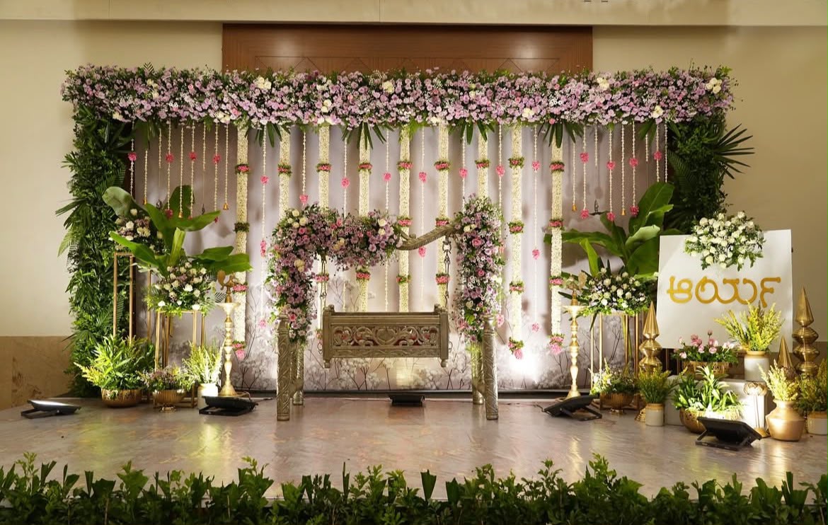 Classic festive backdrop with rich crimson drapes, golden archwork, and fresh jasmine vines