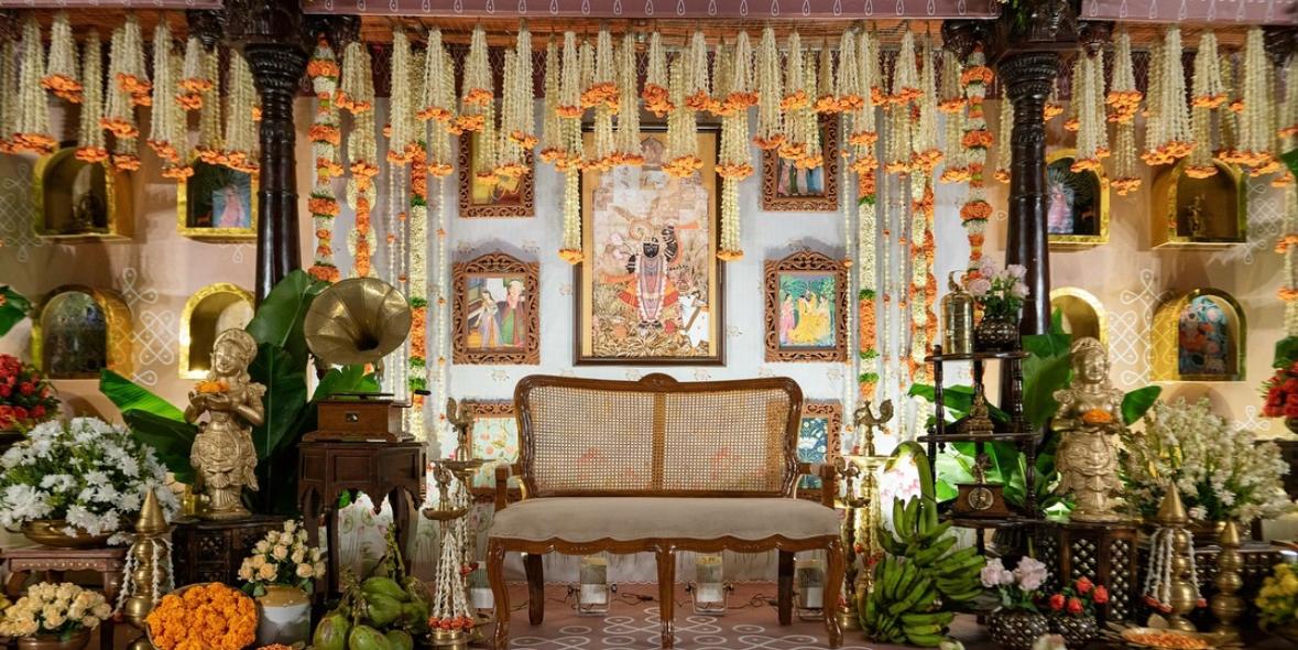 Traditional pooja altar styling with marigold garlands, coconut kalash, and brass tableware