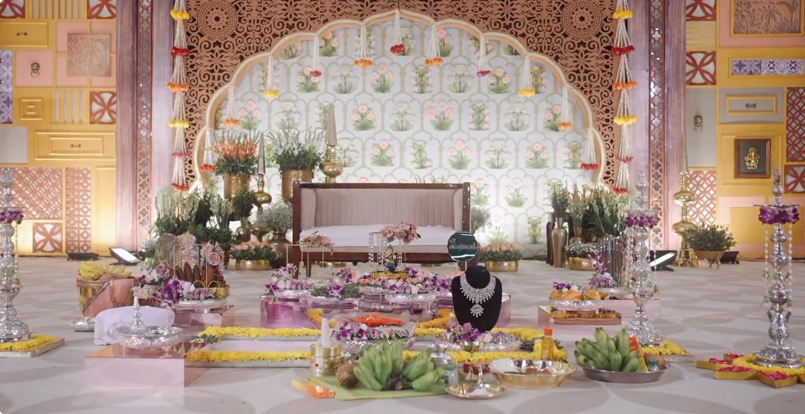 Royal traditional backdrop featuring golden temple gopuram arch and hanging floral strings