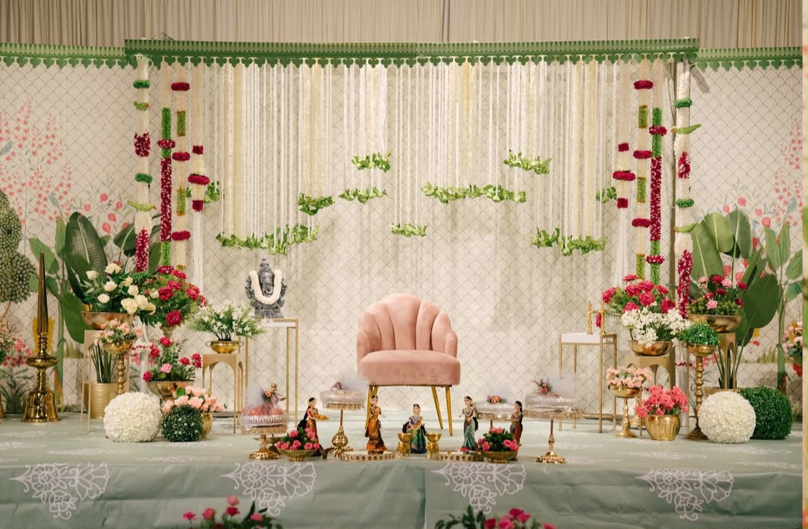 Traditional family celebration hall styled with symmetrical floral arches and festive lighting