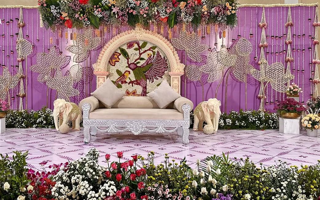 Festive prayer altar surrounded by brass temple bells and fragrant marigold curtains