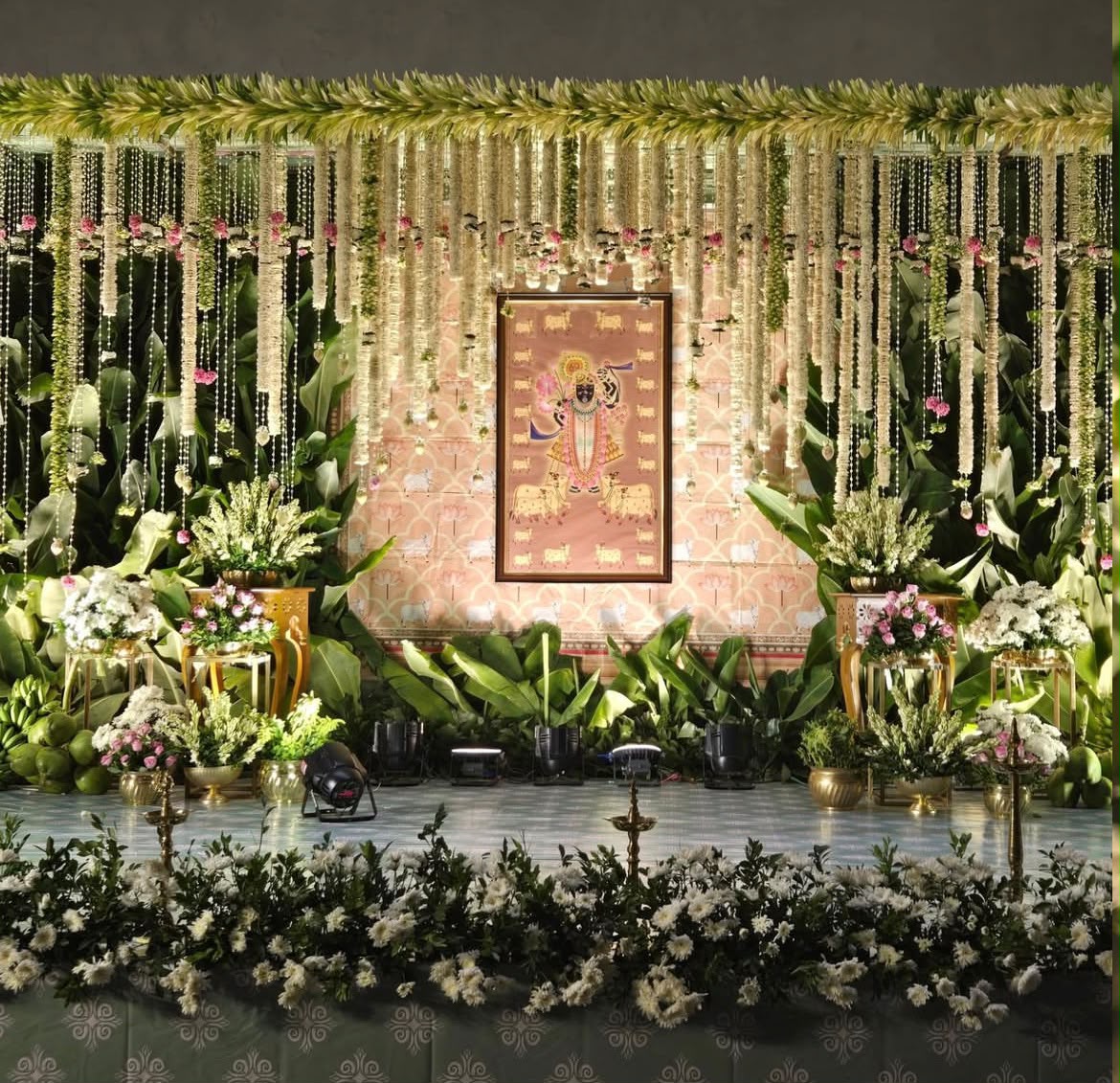 Heritage celebration stage setup with warm wood finishes, fresh roses, and hanging floral drops