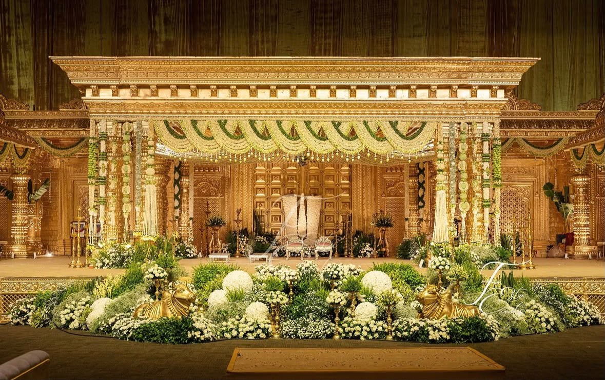 Majestic wedding mandap with green velvet drapery and cascading floral tassels