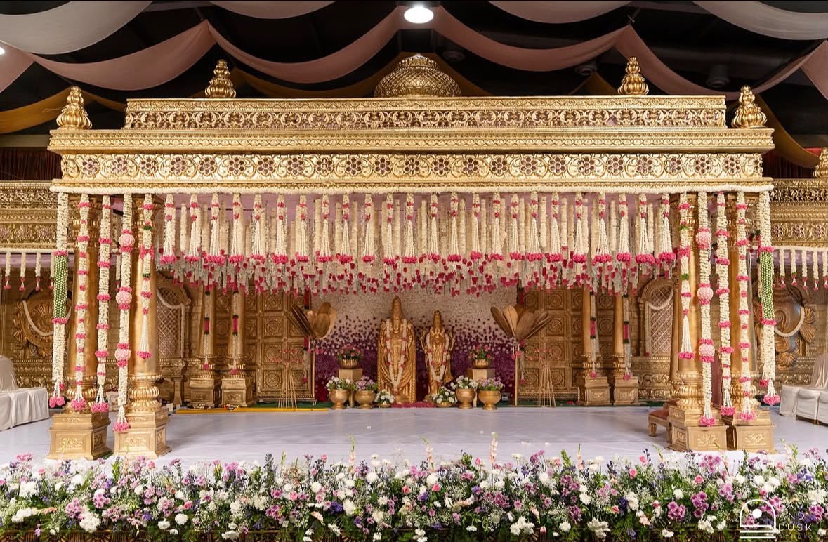 Golden wedding mandap with pink and white flower garlands