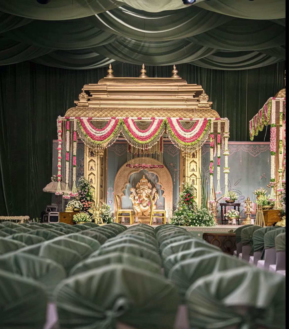 Ethereal white and green wedding stage production with circular ceiling canopy