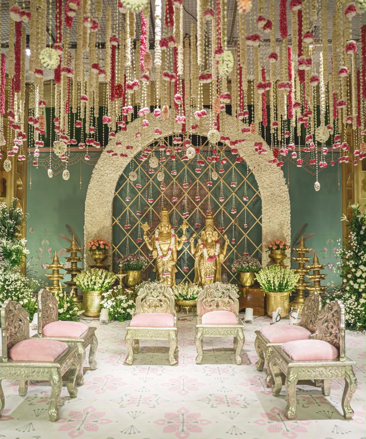 Intimate sacred mandap setting with brass urlis, lamps, and fresh tuberose