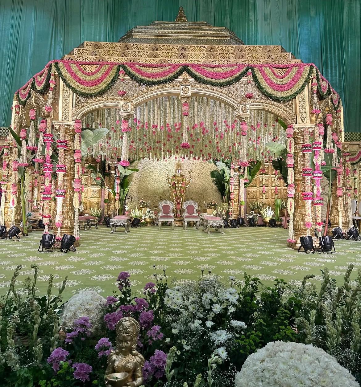 Contemporary Indian wedding stage with floral ombre cascades and pinspot lighting